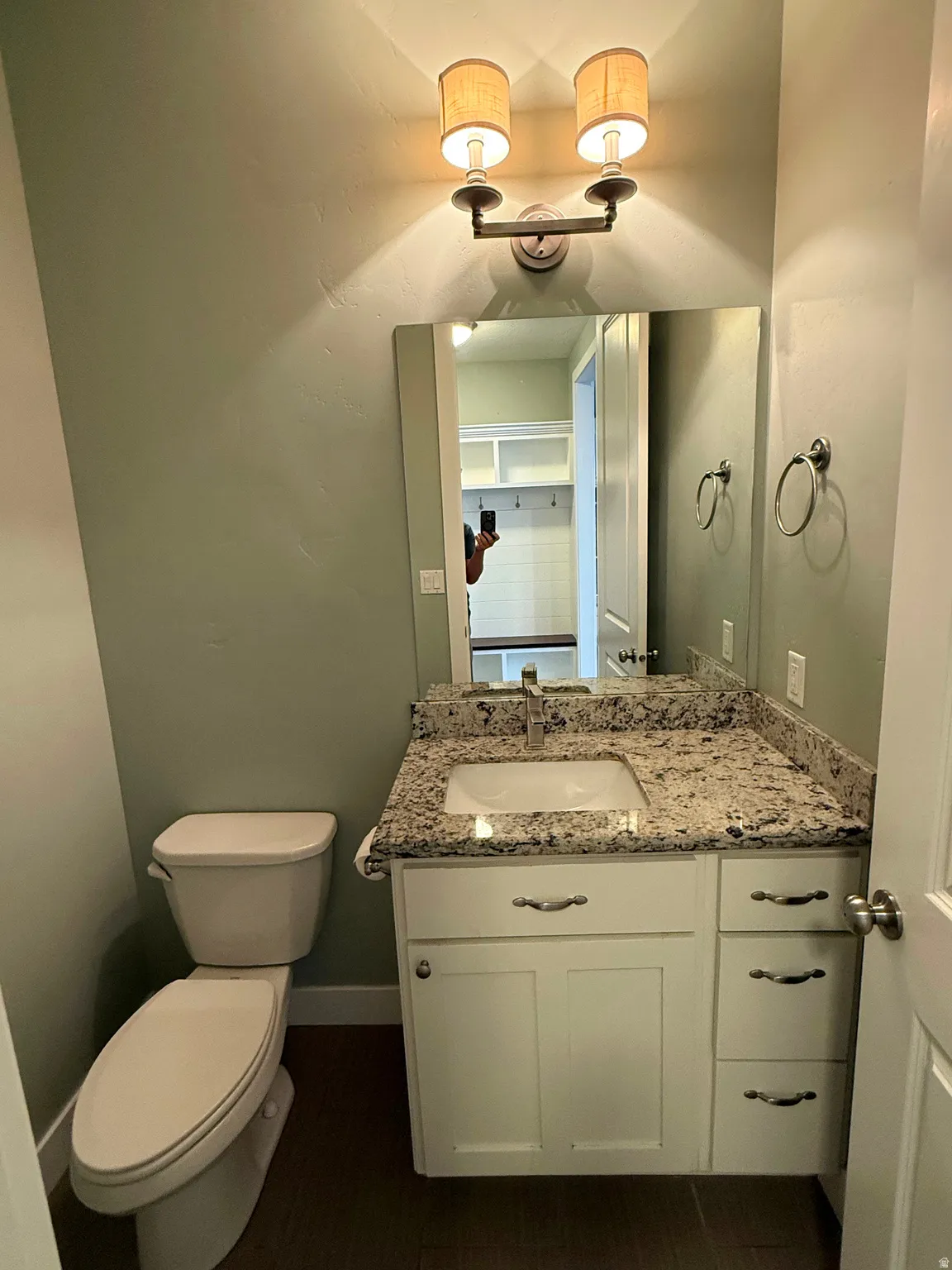 Well-appointed bathroom featuring a white vanity with shaker-style cabinetry, granite countertop, and undermount sink