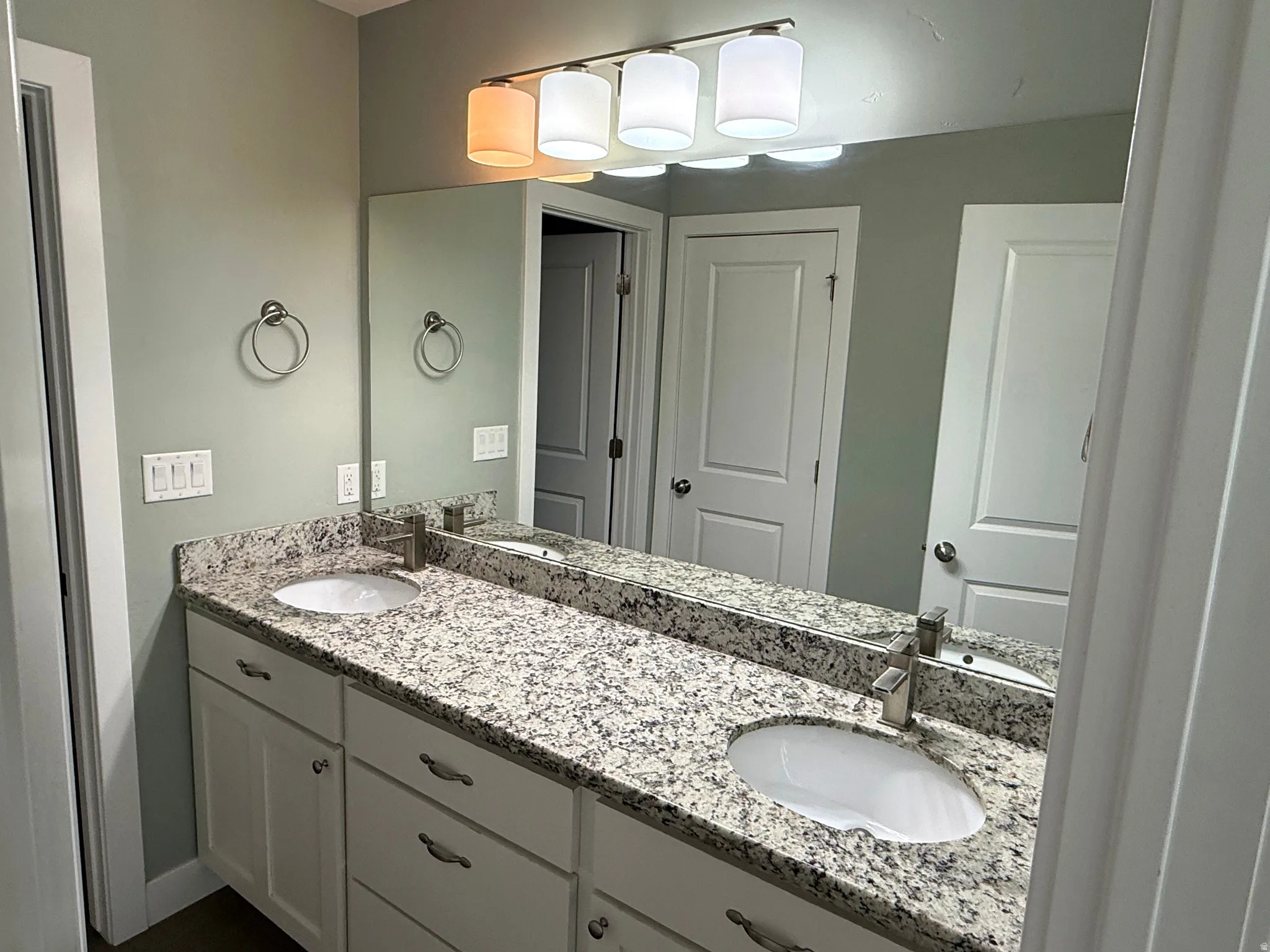 Dual vanity with granite-style countertop, undermount sinks, and brushed nickel fixtures