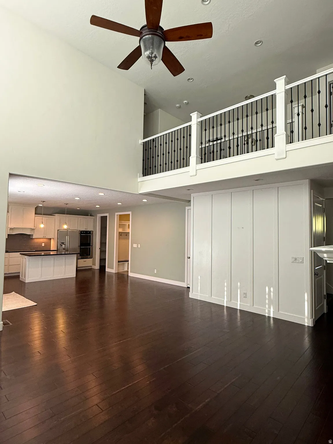 Open concept living space featuring wood-finish flooring and a two-story ceiling