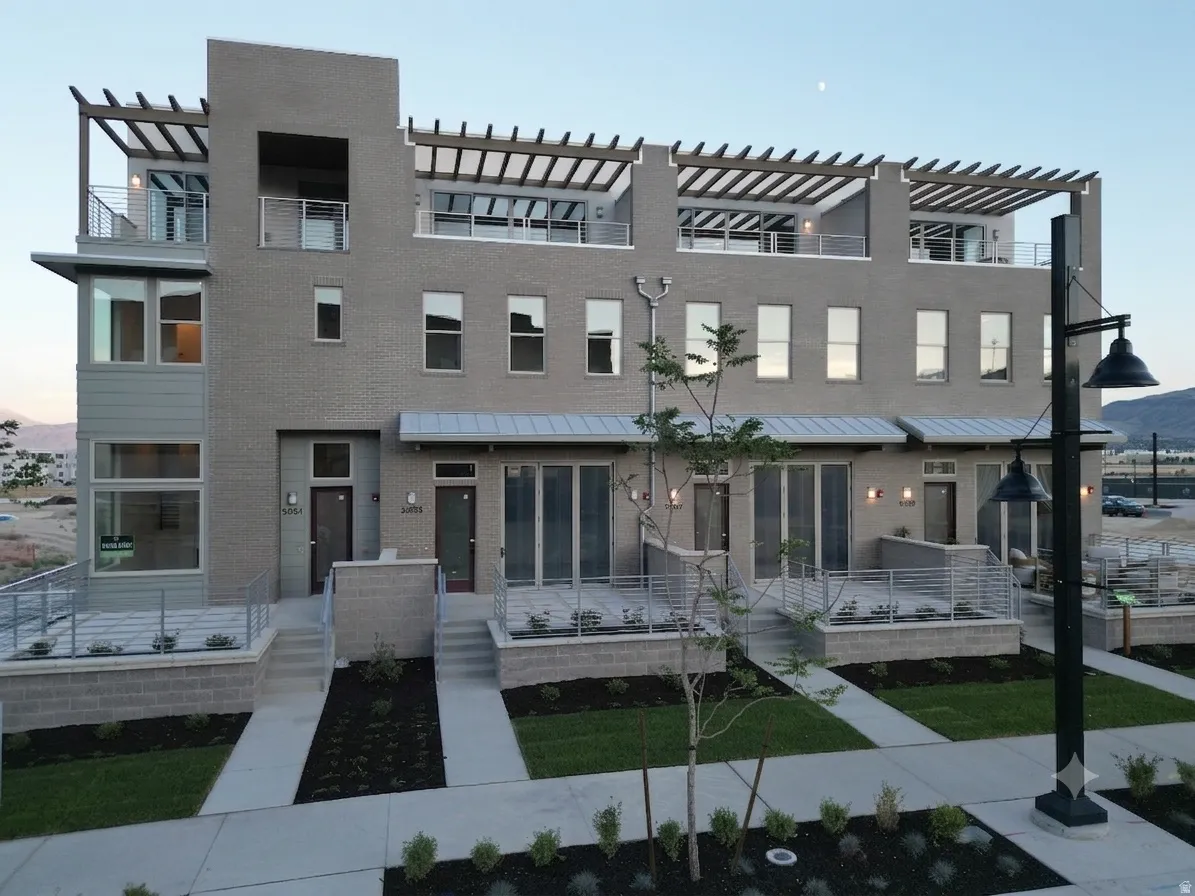 Contemporary multi-story townhomes featuring light gray brick and horizontal siding accents