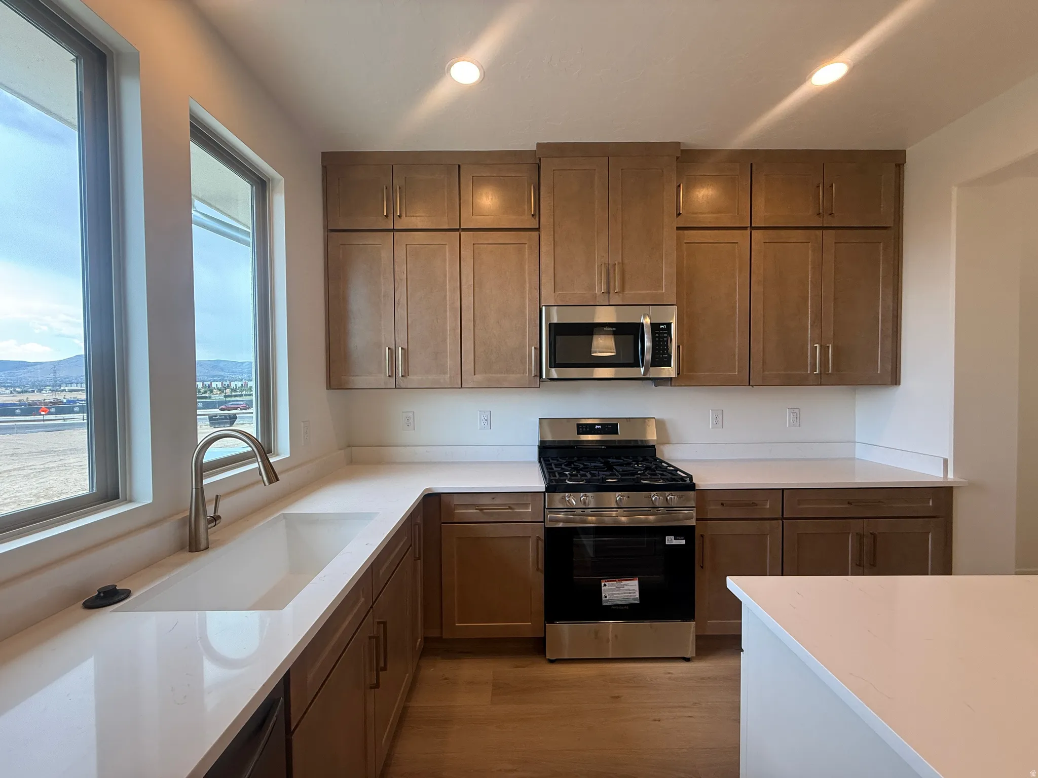 Modern kitchen featuring light wood-finish cabinetry and white countertops