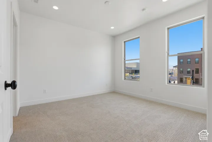 Neutral-toned wall-to-wall carpeting, recessed ceiling lighting, and dual single-hung windows