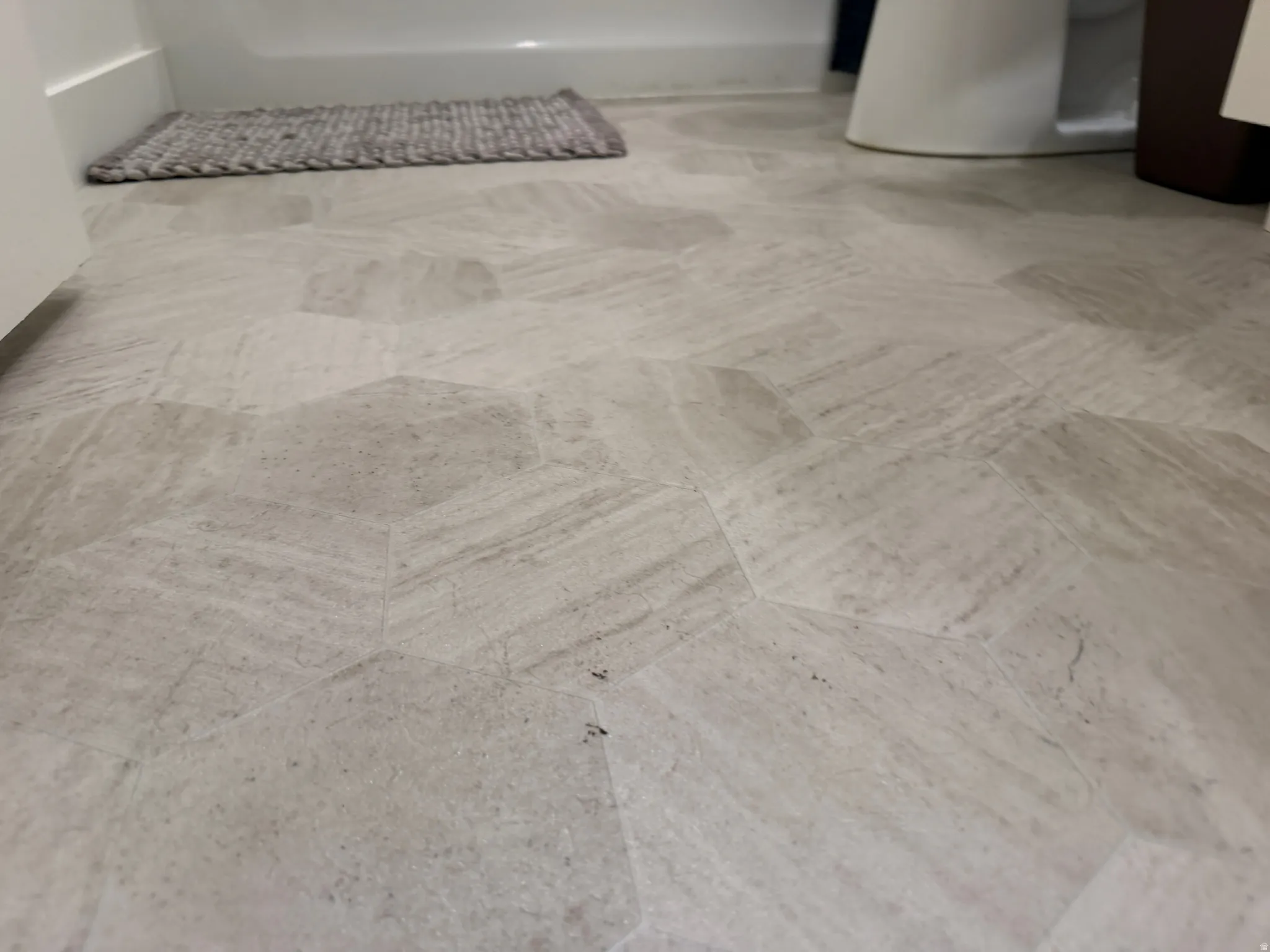 Hexagonal floor tiling in a light-toned, wood-grain pattern