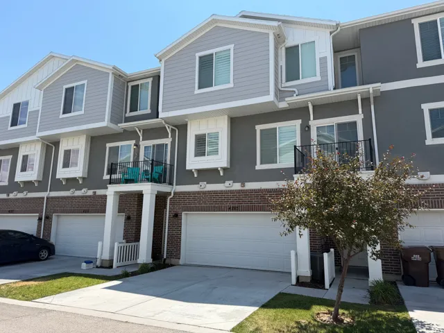 Modern townhome exterior featuring a two-tone facade with light grey siding and darker grey stucco