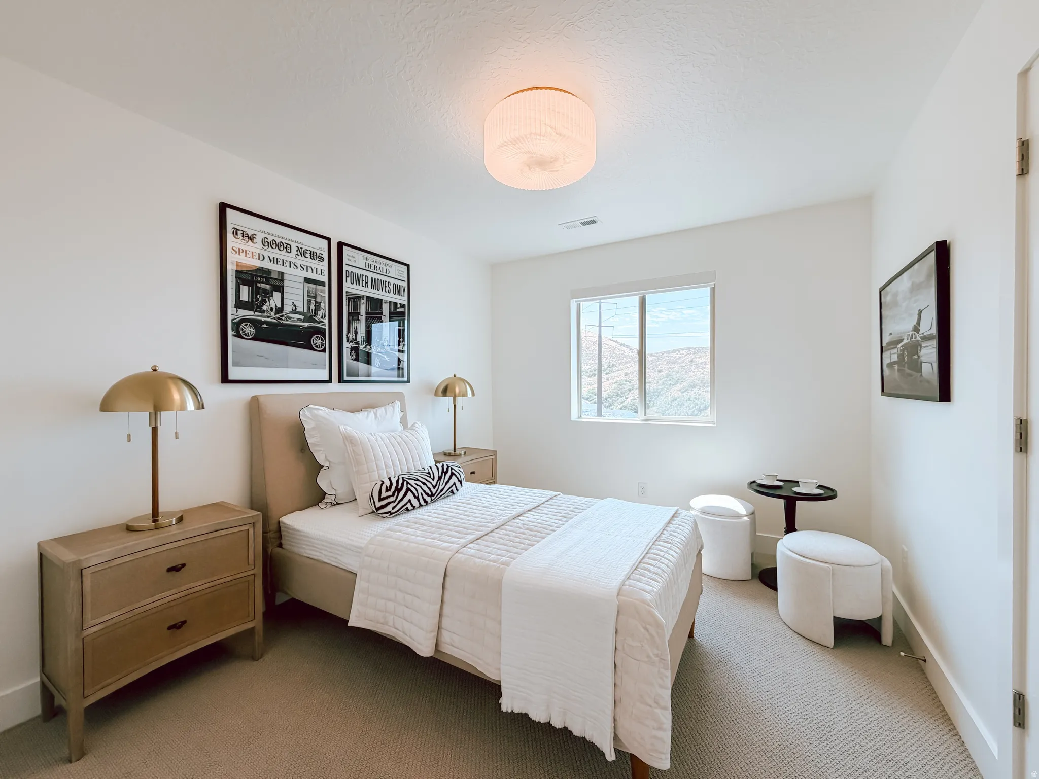 Bright room featuring a horizontal window, white walls, and neutral carpeting