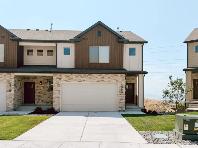 Contemporary townhome exterior featuring a stacked stone facade and brown vertical siding