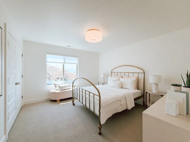 Neutral carpet flooring, white walls, and a window featuring a mountain backdrop