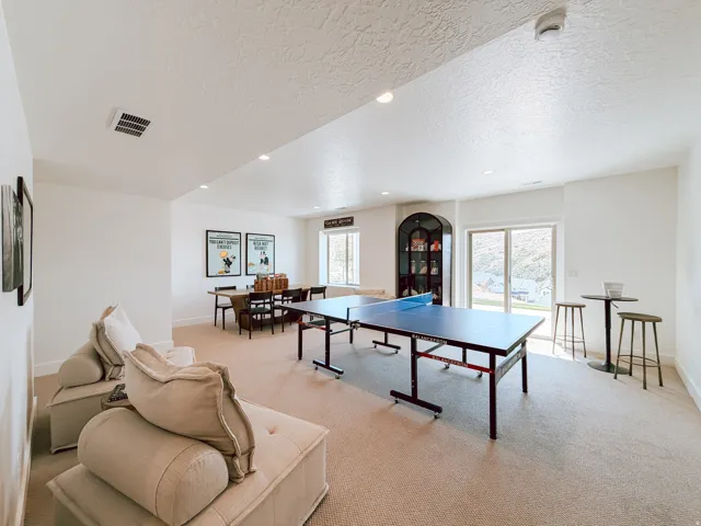 Spacious recreation room featuring light-toned carpeting and recessed lighting