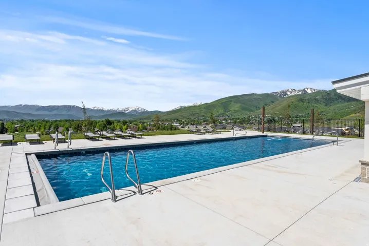 Rectangular swimming pool featuring integrated water features and a surrounding concrete deck