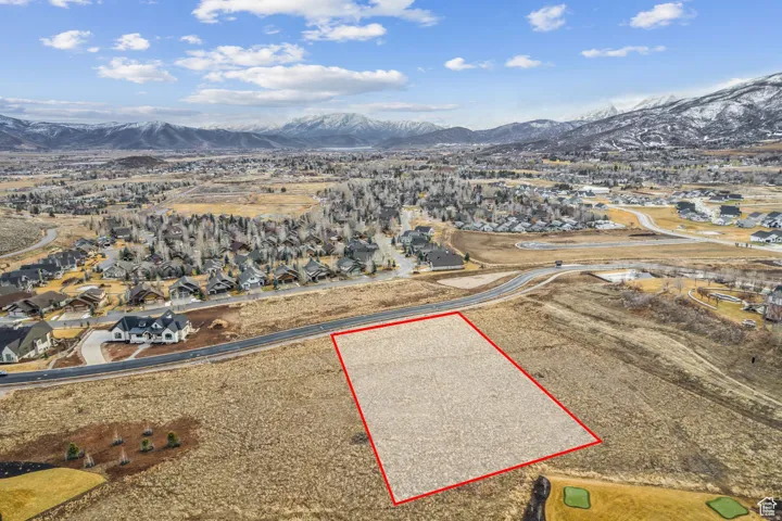 Expansive vacant land parcel, outlined in red, featuring a flat, buildable surface