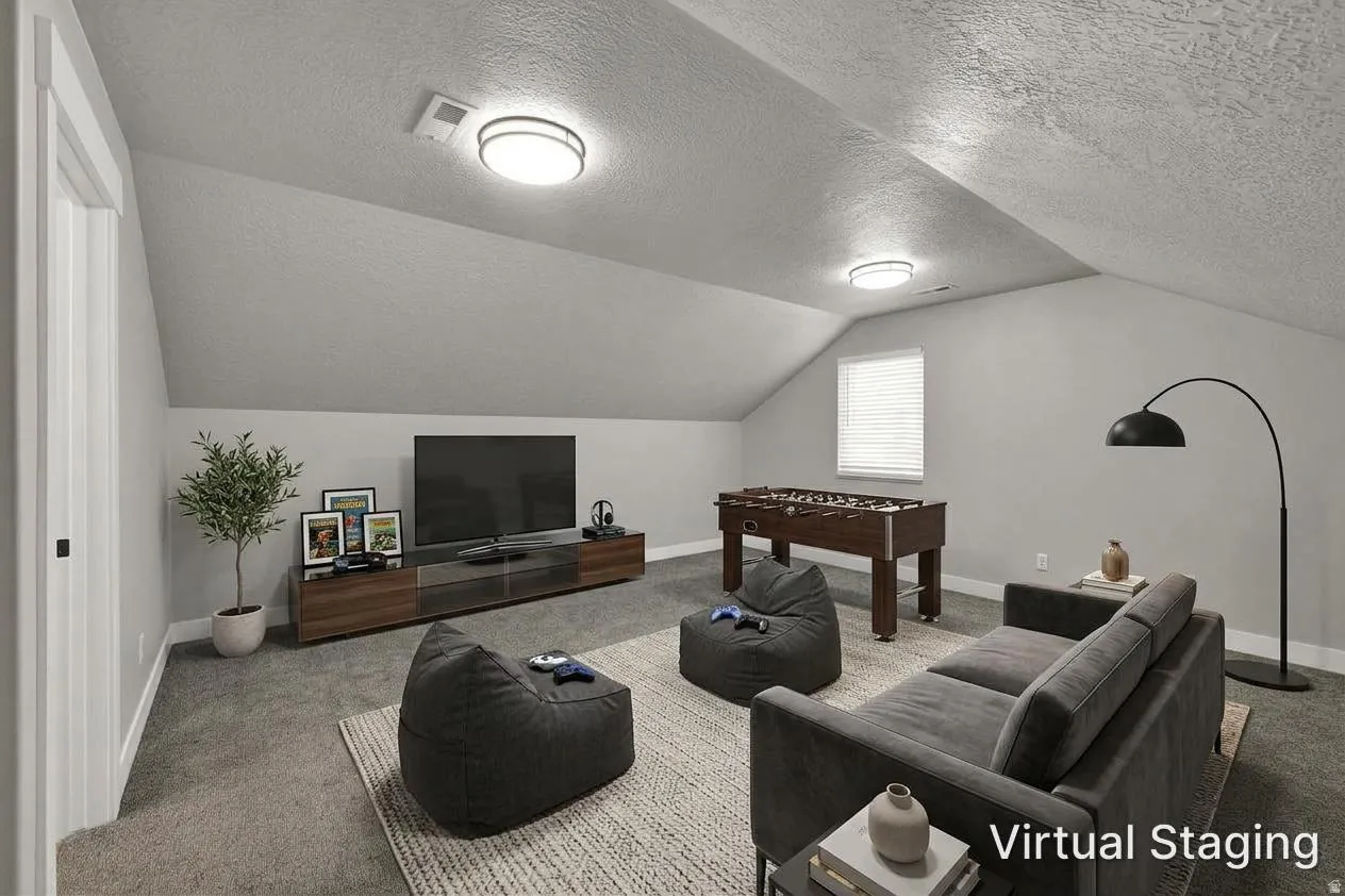 Vaulted ceiling with flush-mount lighting, wall-to-wall carpeting, and a window with blinds