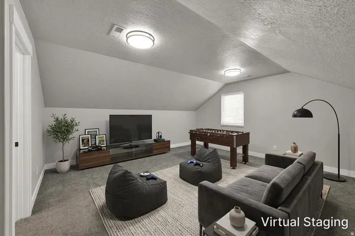 Vaulted ceiling with flush-mount lighting, wall-to-wall carpeting, and a window with blinds