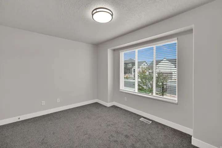 Recessed window with white blinds, grey carpeting, light grey wall paint, and a flush mount ceiling light