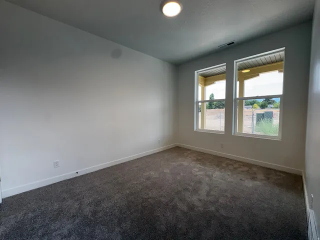 Neutral wall color, plush carpeting, and dual windows
