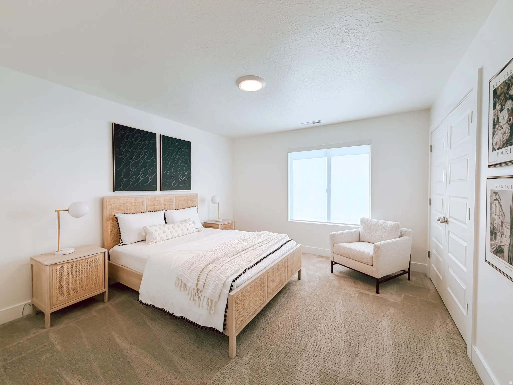 Carpeted room with a recessed window featuring a white roller shade, white baseboards, and a paneled door