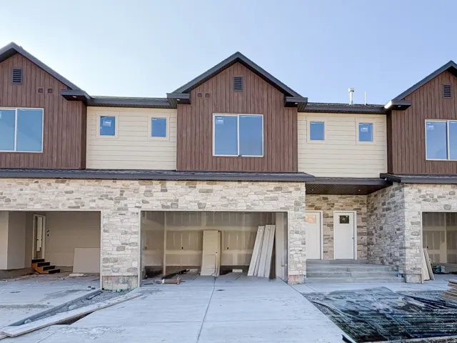 Modern townhome facade featuring a stone and siding exterior