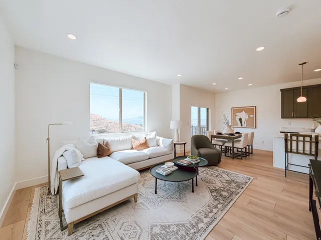 Open-concept living space featuring wood-finish flooring, recessed lighting, and large windows
