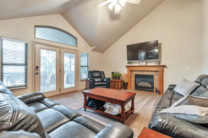 Spacious living area featuring a vaulted ceiling and an arched transom window