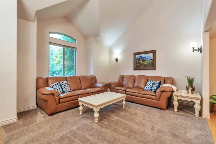 Living area with vaulted ceilings and wall sconces
