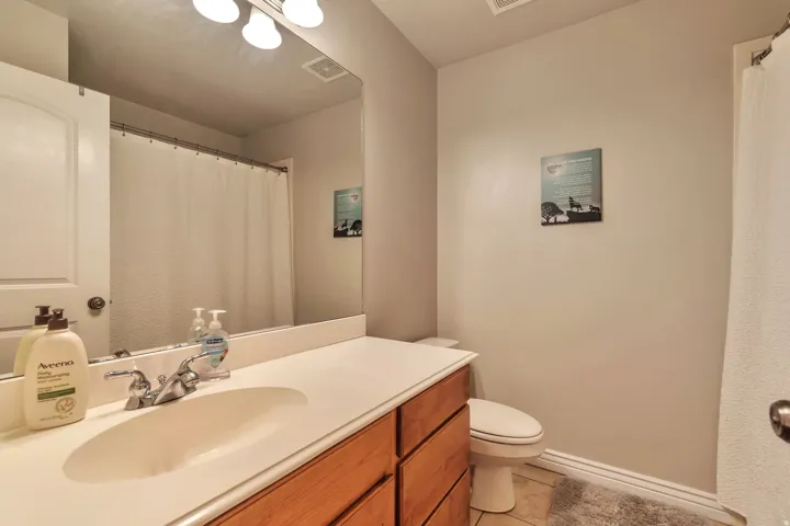Bathroom vanity featuring a light-toned countertop with an integrated sink and chrome faucet