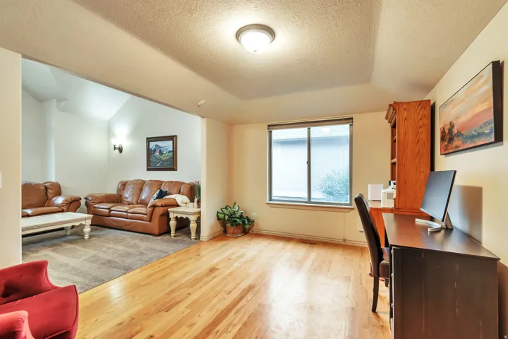 Open concept living space featuring wood-finish flooring, a neutral color palette, and a recessed ceiling