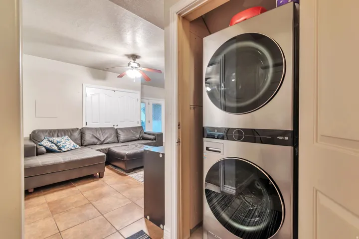 Integrated laundry closet featuring stacked stainless steel appliances