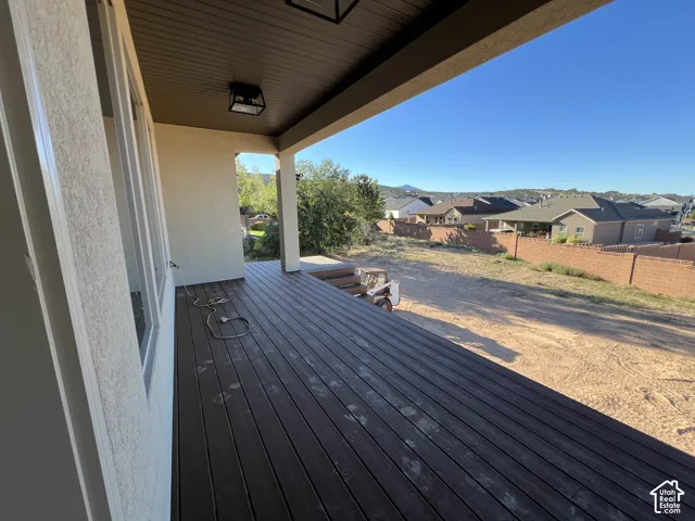 Expansive covered deck featuring dark wood-finish decking and integrated lighting