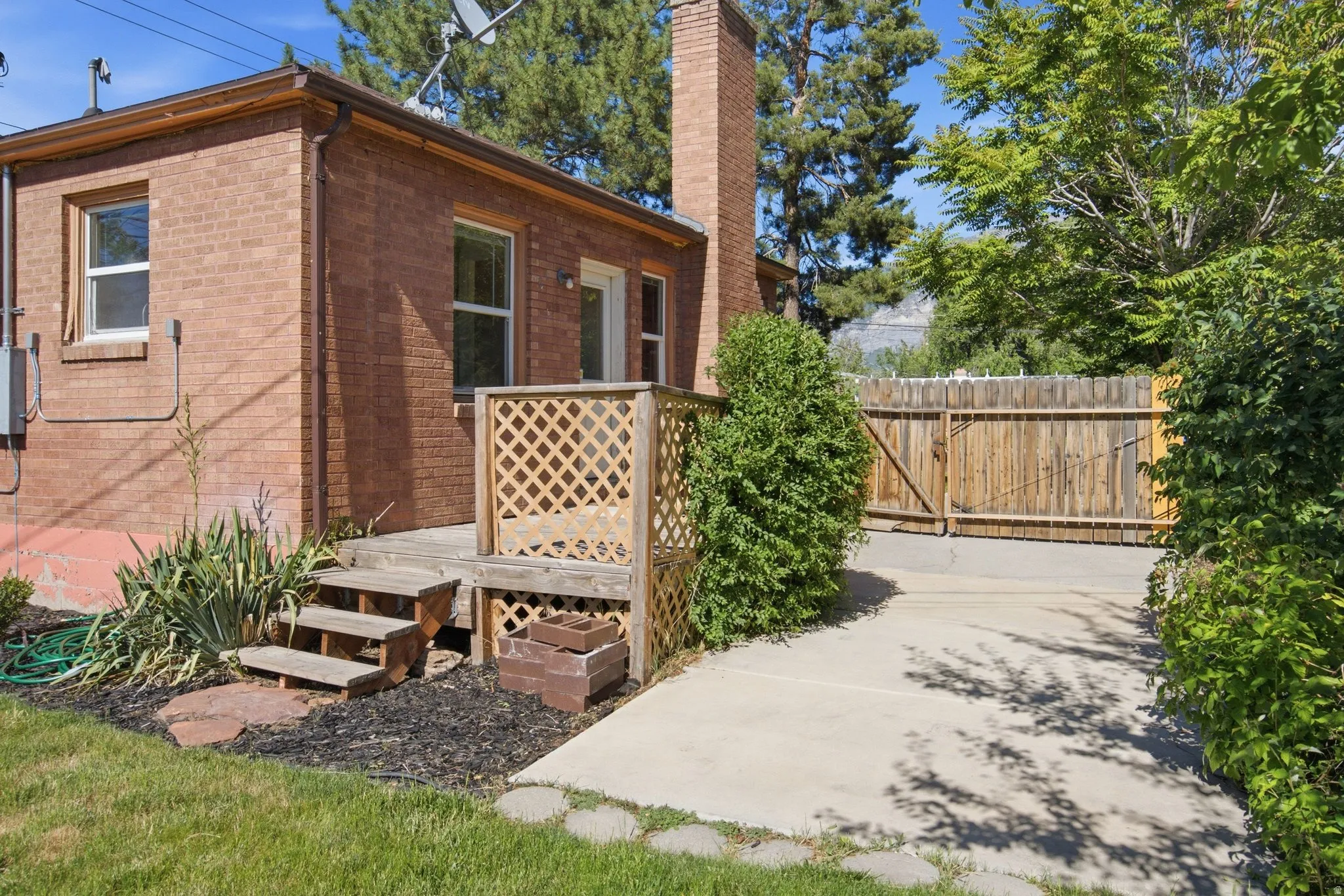 Brick exterior featuring a wooden deck with lattice railing