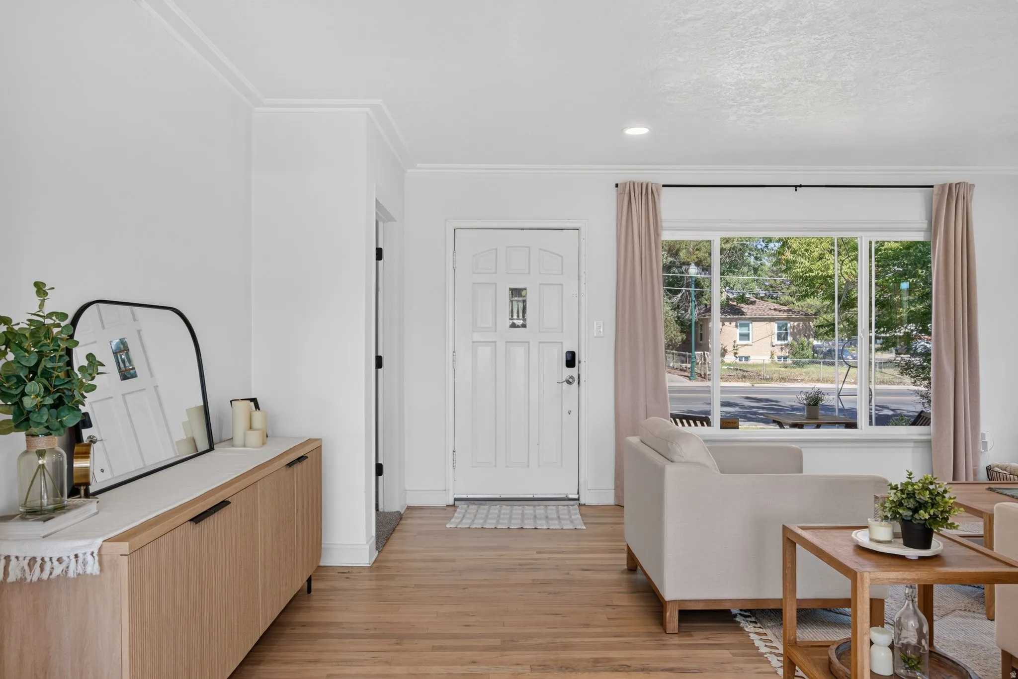 Entryway featuring a panel door, wood-finish flooring, and crown molding