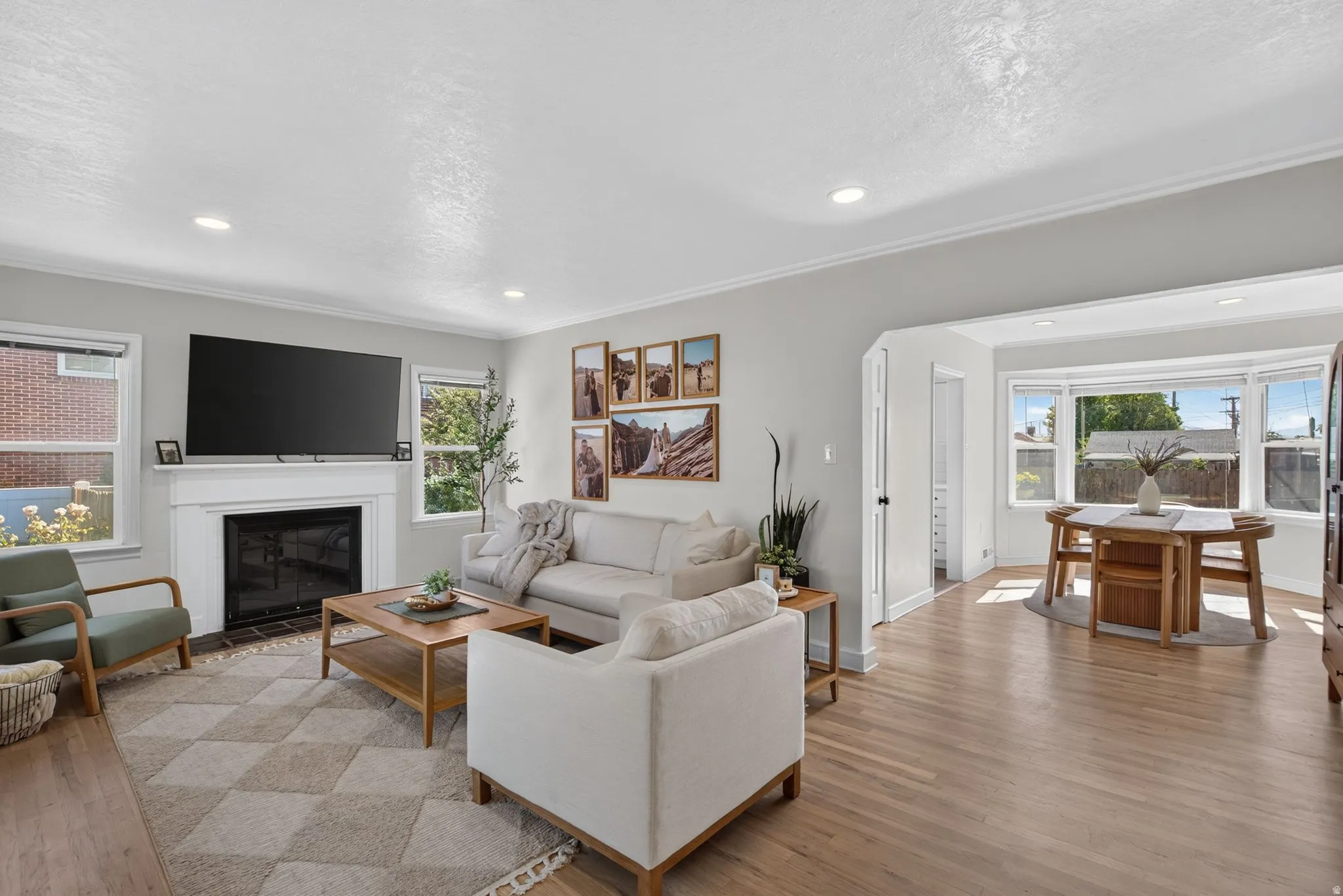 Living area featuring a fireplace with a white mantel, recessed lighting, and wood-finish flooring