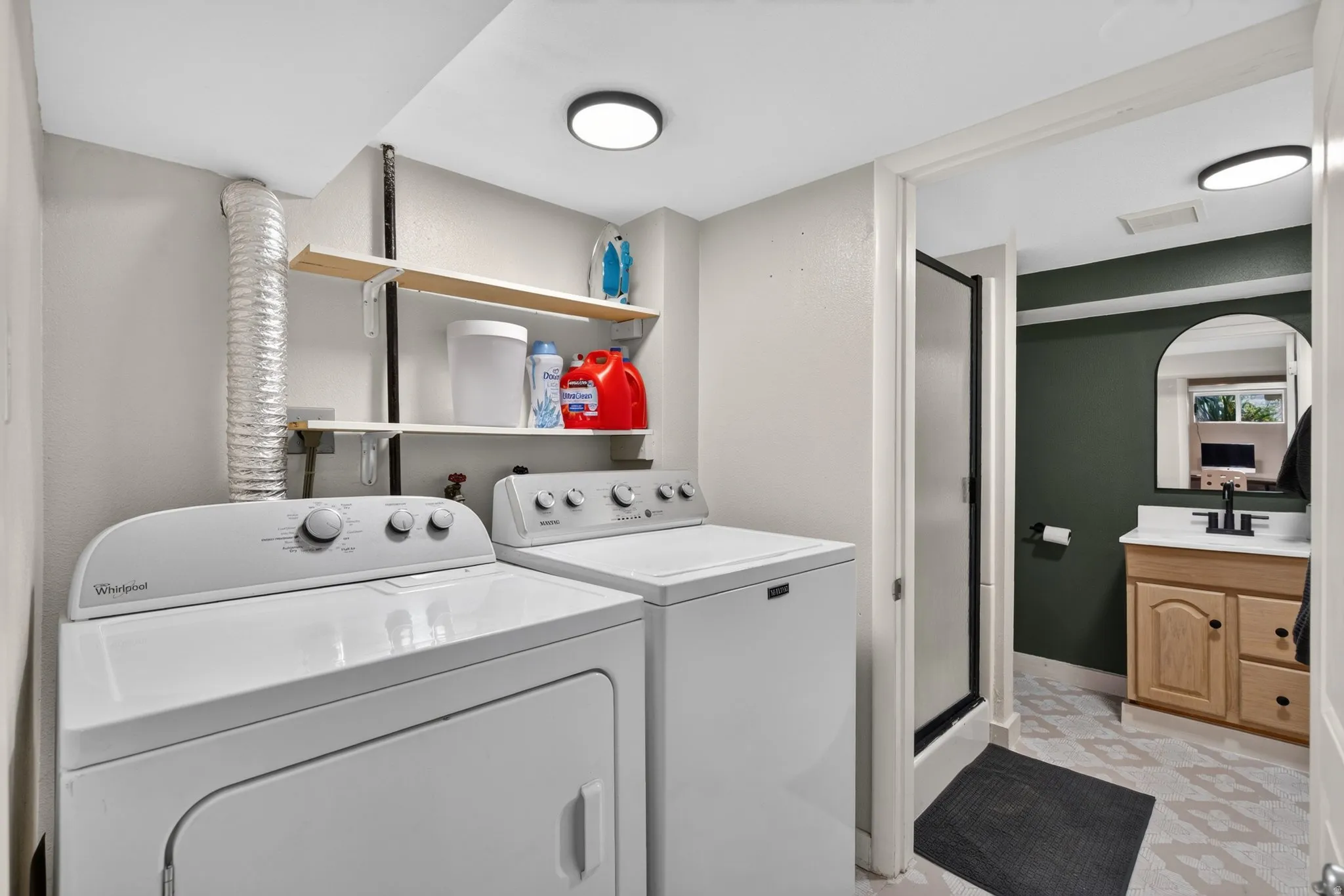 Dedicated laundry area with upper shelving and an adjacent full bathroom