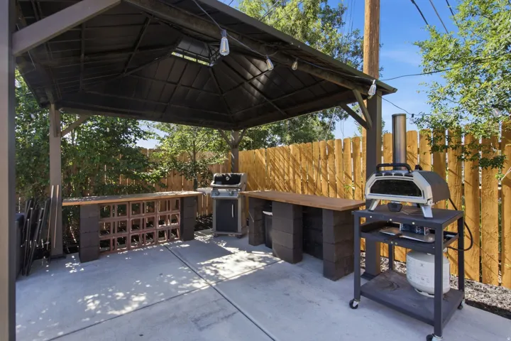 Outdoor living space featuring a dark-toned pergola with integrated lighting