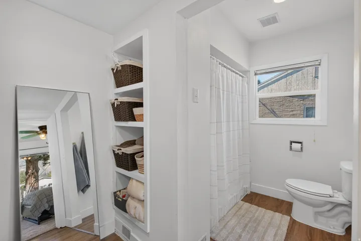 Bright bathroom with wood-finish flooring and a shower/tub combination