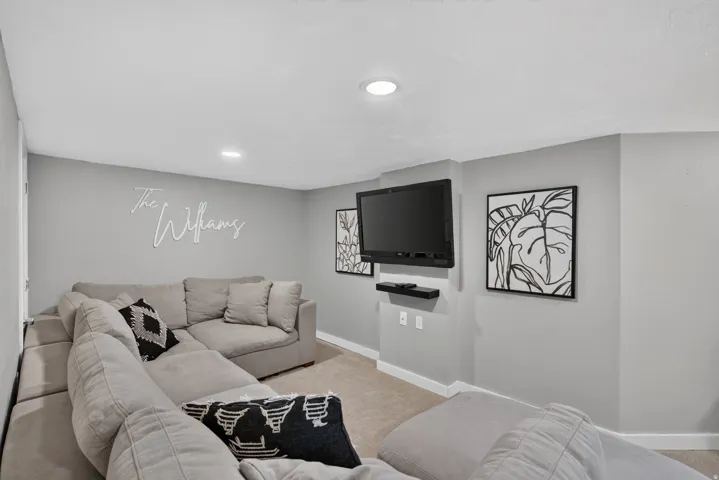 Carpeted interior space featuring light gray walls, white trim, and recessed lighting