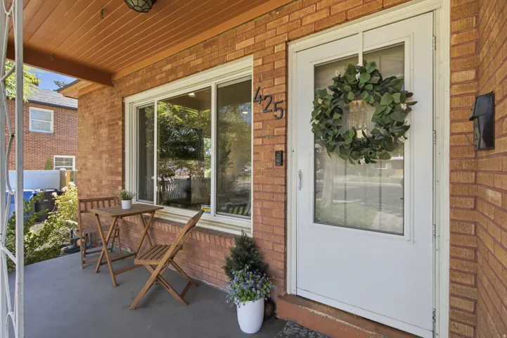Brick exterior featuring a covered front porch with a wood-plank ceiling