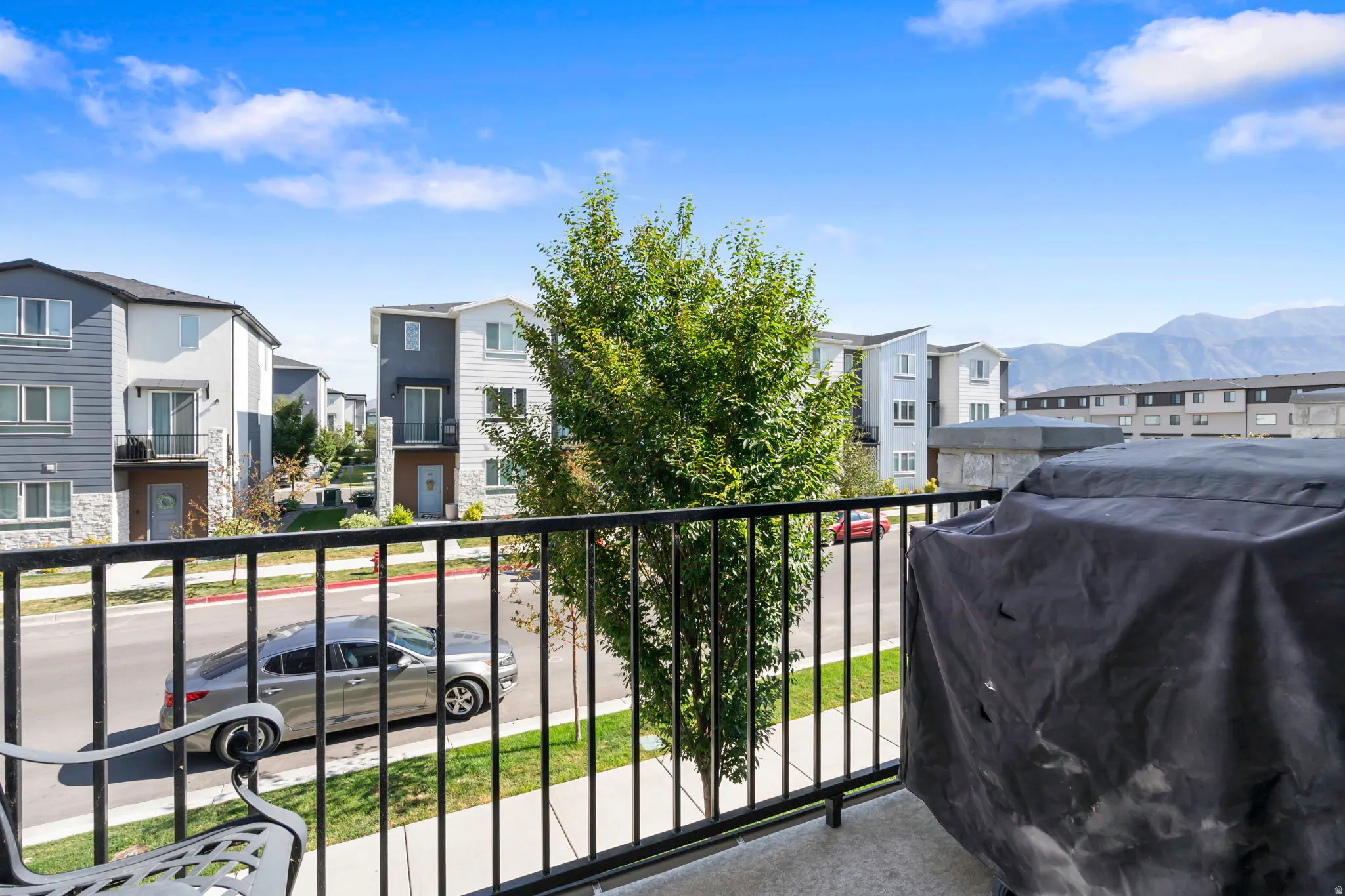 Balcony with black metal railing overlooking a residential street