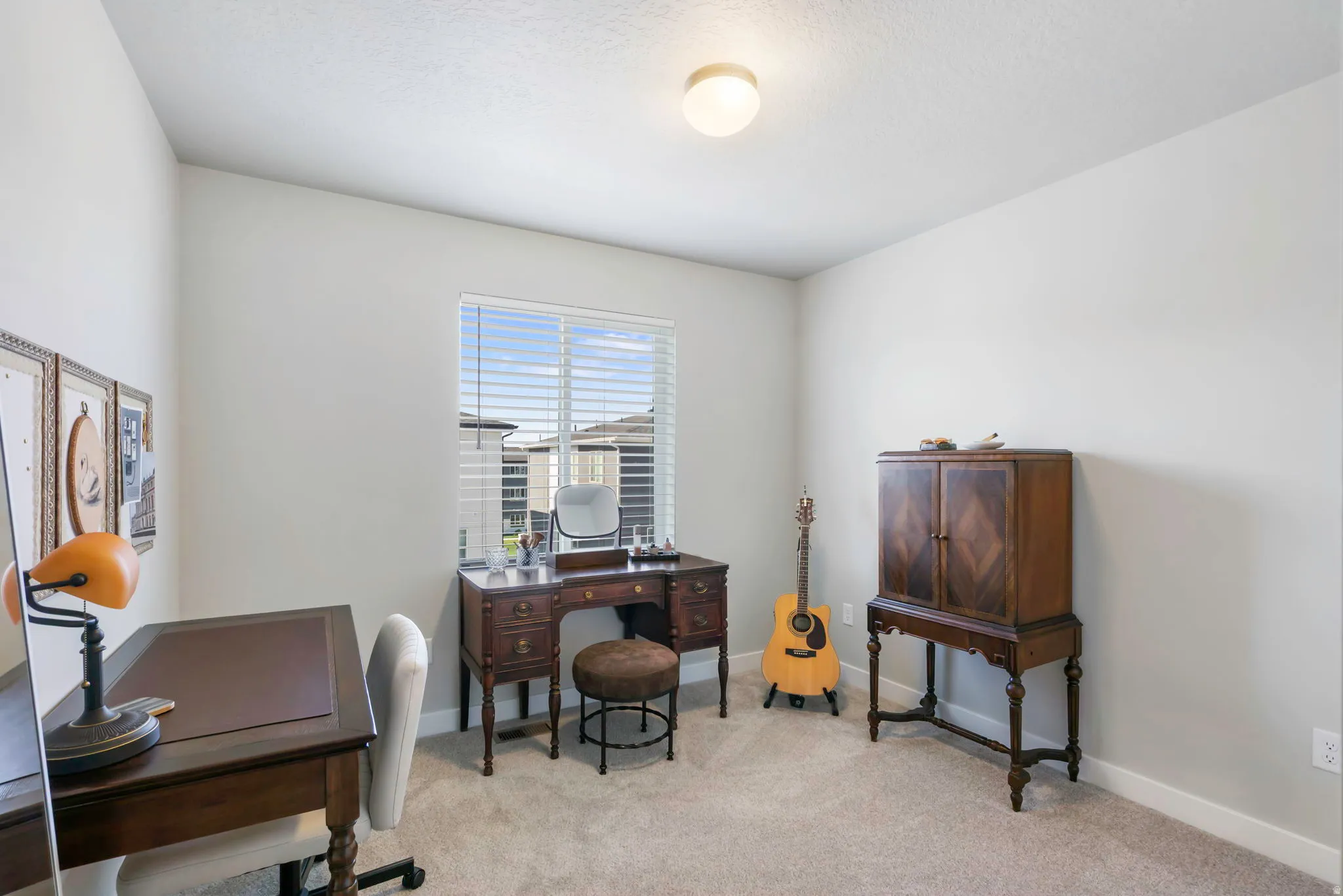 Carpeted room with neutral wall paint and a single window featuring horizontal blinds