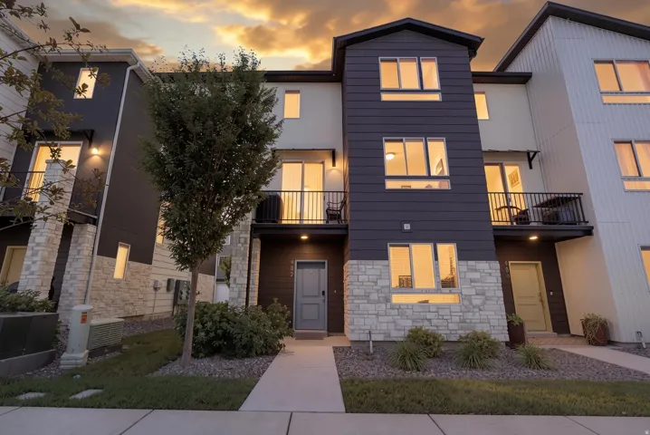 Modern multi-level exterior featuring dark siding and light stone accents