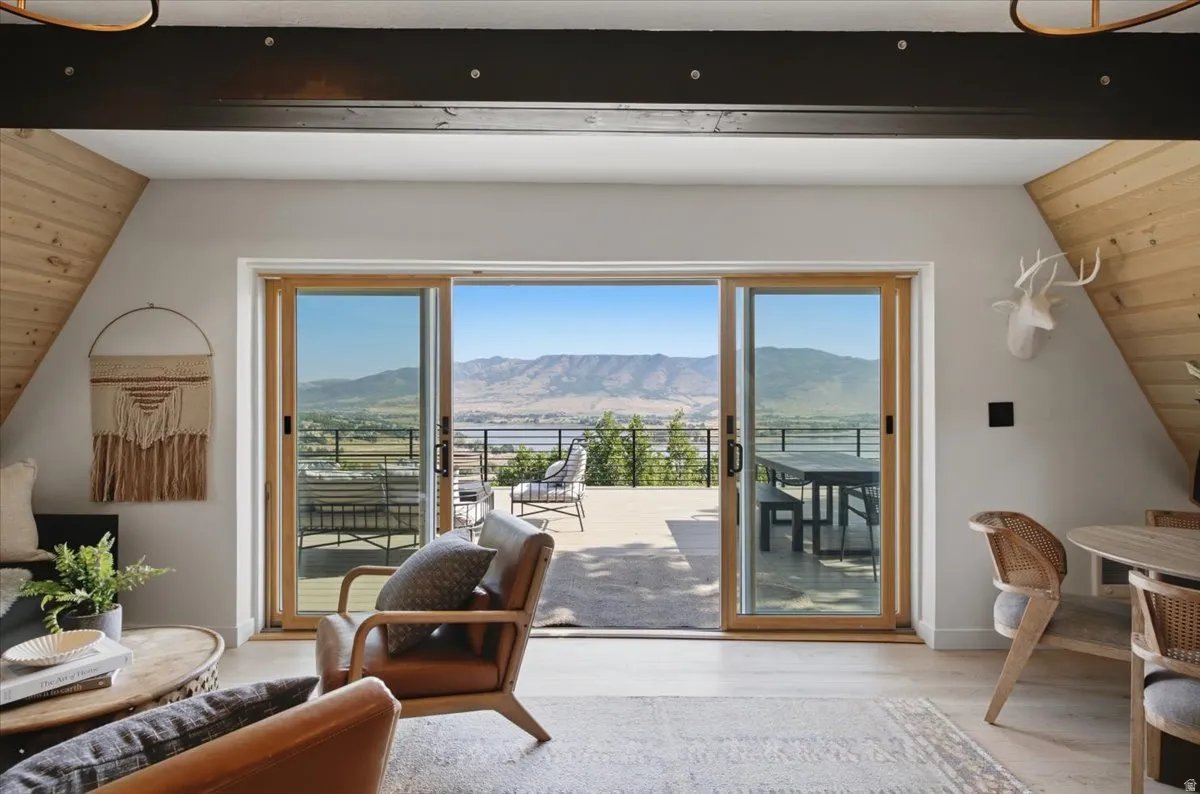 Expansive sliding glass doors opening to an outdoor deck with a mountain backdrop