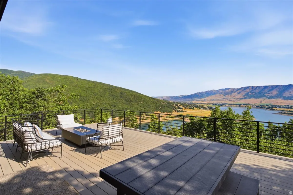 Expansive outdoor deck featuring composite decking, a linear railing system, and a mountain and lake backdrop