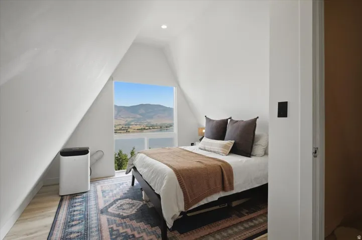 Room featuring a large picture window, a recessed ceiling light, and wood-finish flooring