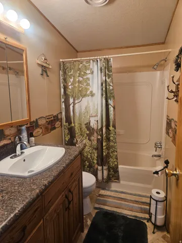 Bathroom featuring a vanity with a laminate countertop, integrated sink, and wood-finish cabinetry