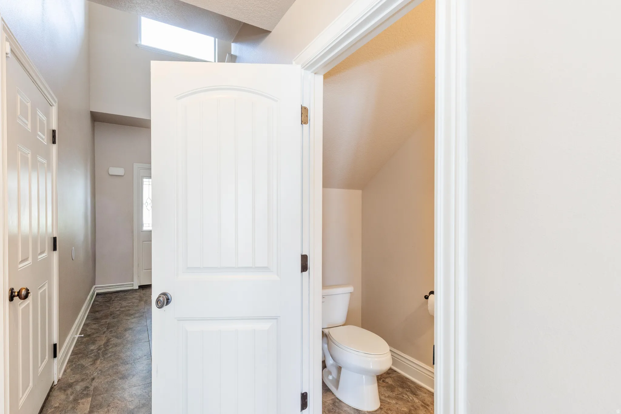 Entryway featuring high ceilings, a transom window, and wood-finish flooring