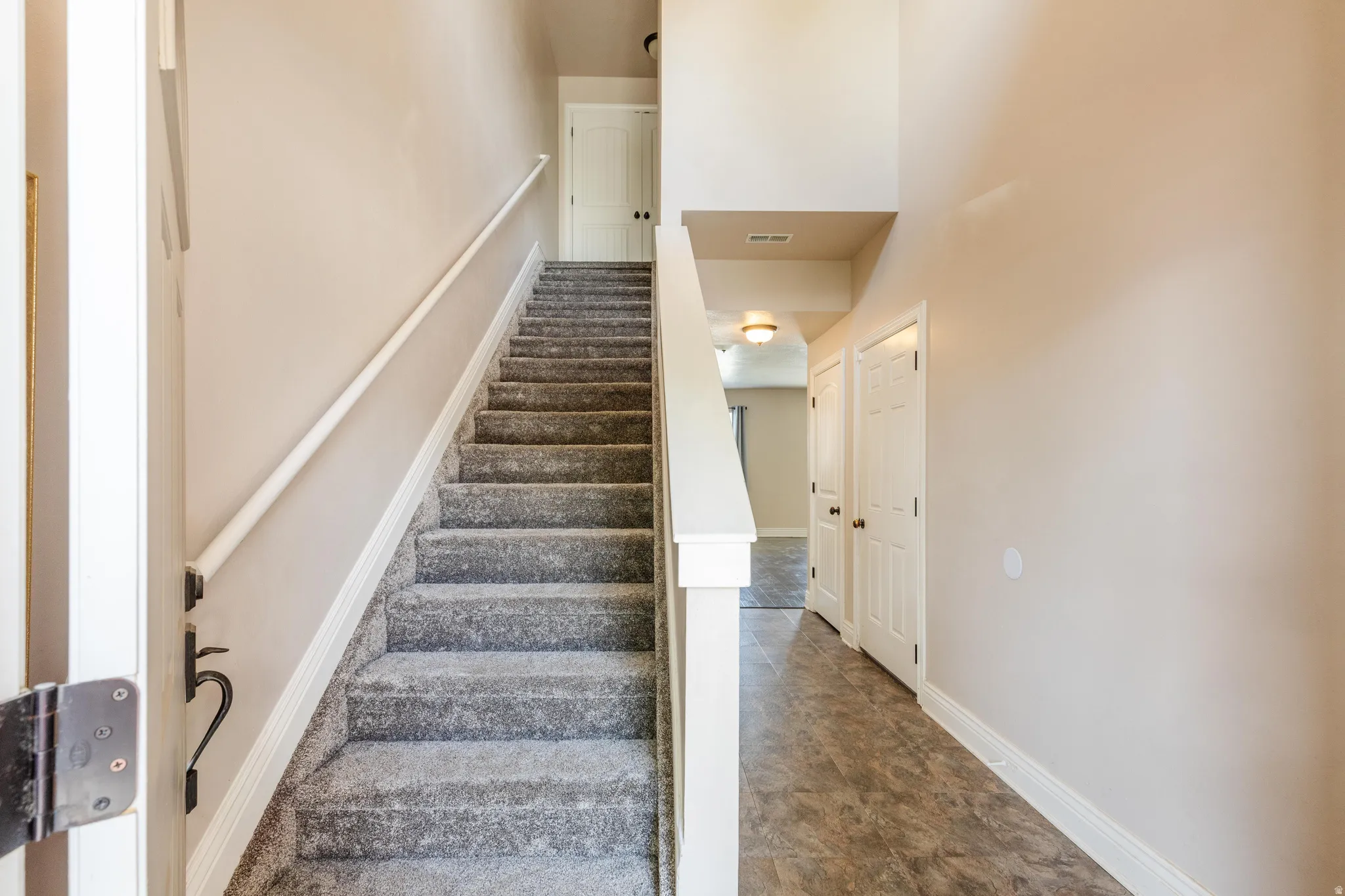 Carpeted staircase with white trim leading to an upper level