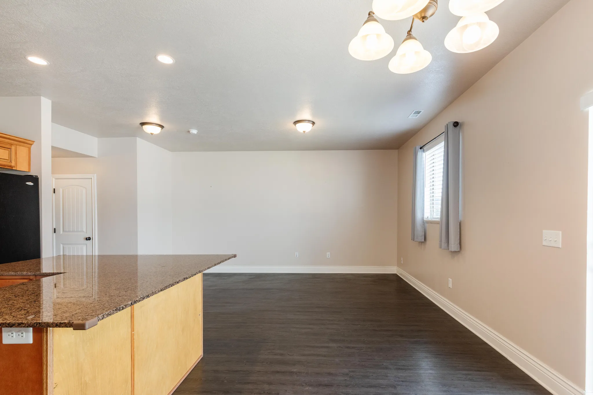 Kitchen island featuring a polished granite countertop and light wood-finish cabinetry