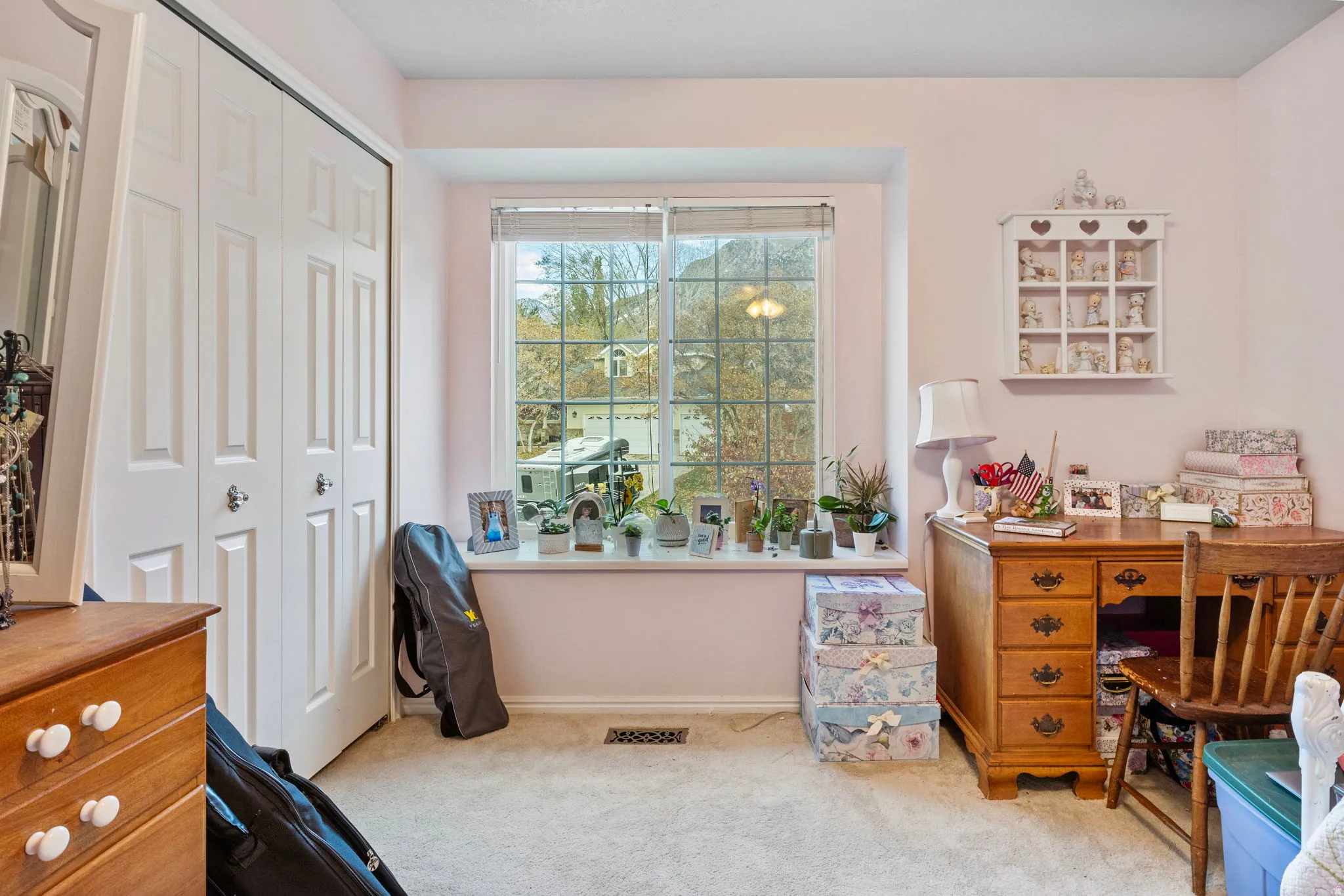 Window-framed room featuring a closet with bi-fold paneled doors, light-toned carpeting, and a built-in window sill