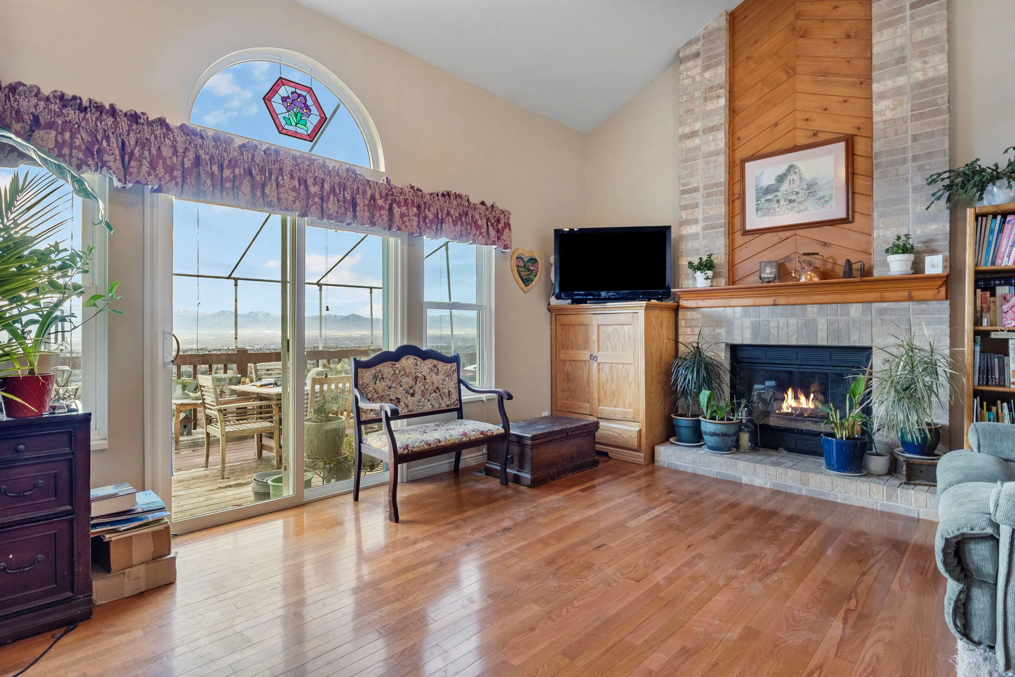 Spacious living area featuring polished wood-finish flooring and a vaulted ceiling