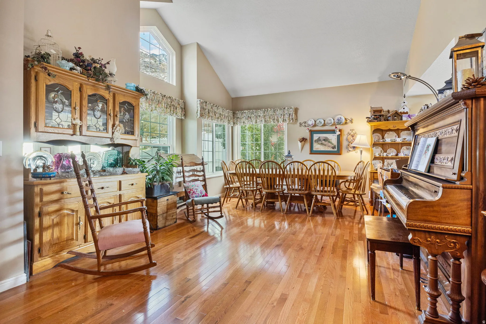 Spacious interior featuring wood-finish flooring, vaulted ceilings, and a dining area with multiple windows