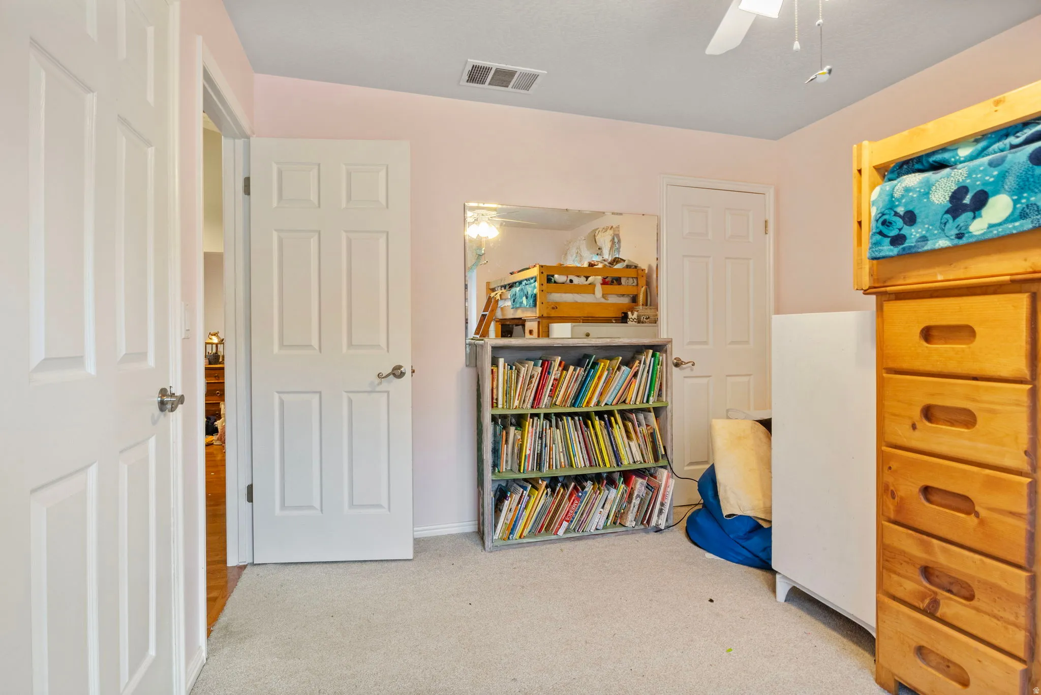 Carpeted room with light pink walls and white trim