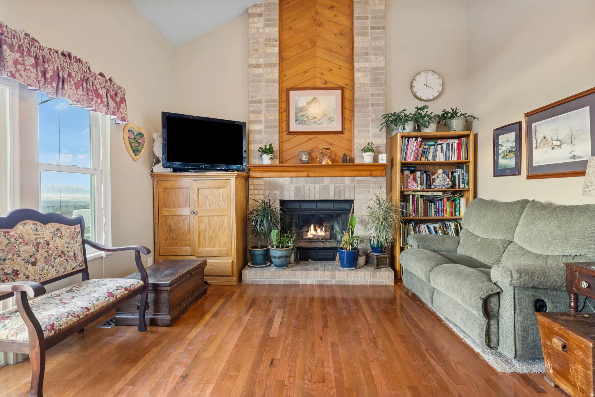 Spacious living area featuring a vaulted ceiling and rich wood-finish flooring